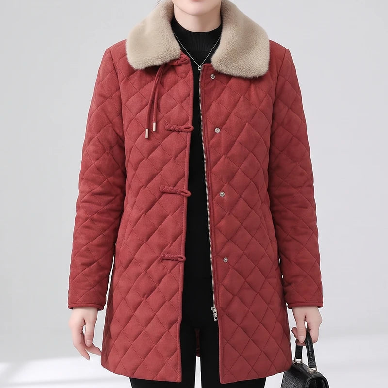 Woman wearing a long, quilted red jacket with a light beige faux fur collar, toggle buttons, and a zipper.