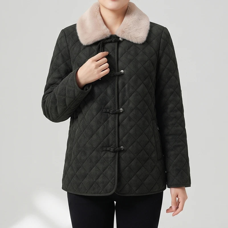 Woman wearing a dark gray quilted jacket with a light pink faux fur collar and toggle button closures.