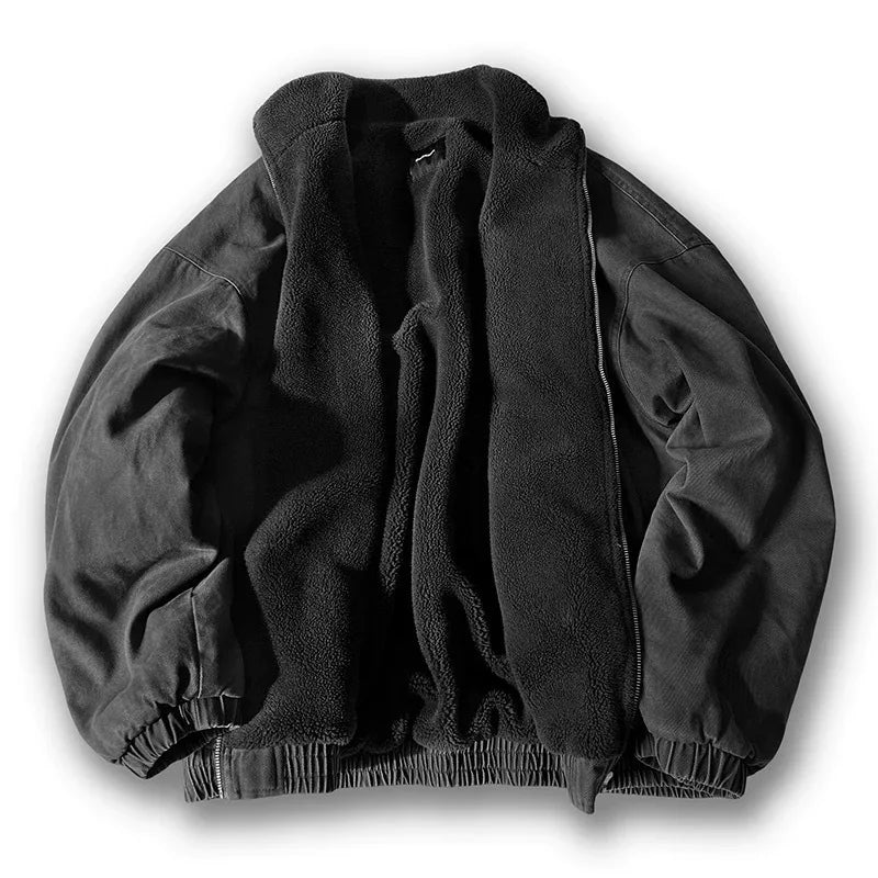 Flat lay of an open washed black jacket featuring thick sherpa fleece lining and elastic hems on a white background.
