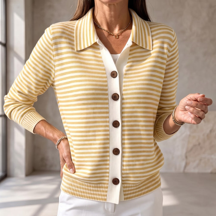 Woman wearing a yellow and cream striped knit cardigan with a ribbed collar, hem, cuffs, and brown buttons.