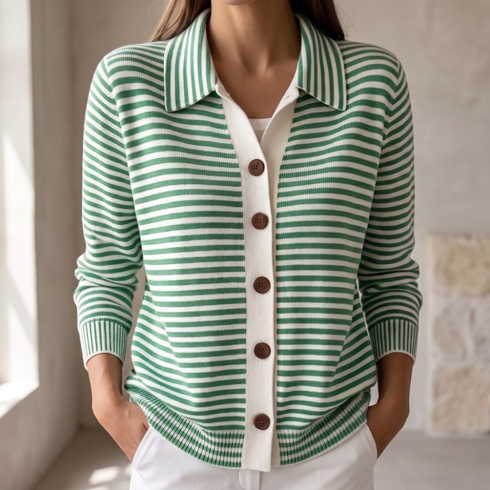 Woman wearing a green and white striped knit cardigan with a ribbed polo collar and brown buttons, hands in pockets.