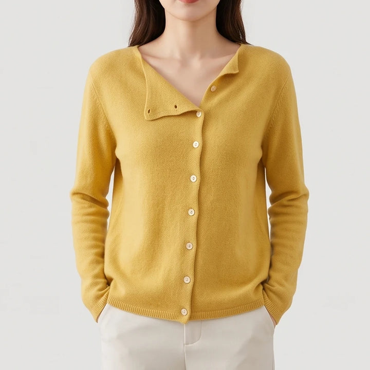 Woman wearing a mustard yellow knit cardigan with an asymmetrical V-neck and a full button-front closure.