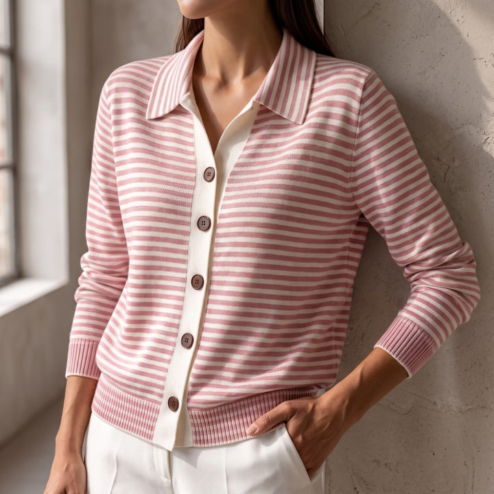Woman wearing a pink and white striped knit cardigan with a collar and dark brown buttons, arm resting by her side.