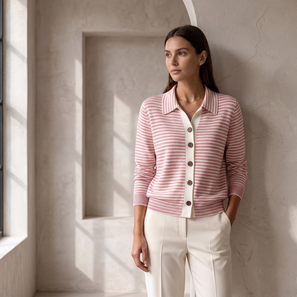 Woman wearing a pink and white striped knit cardigan with a collared neckline and brown buttons, paired with cream trousers.