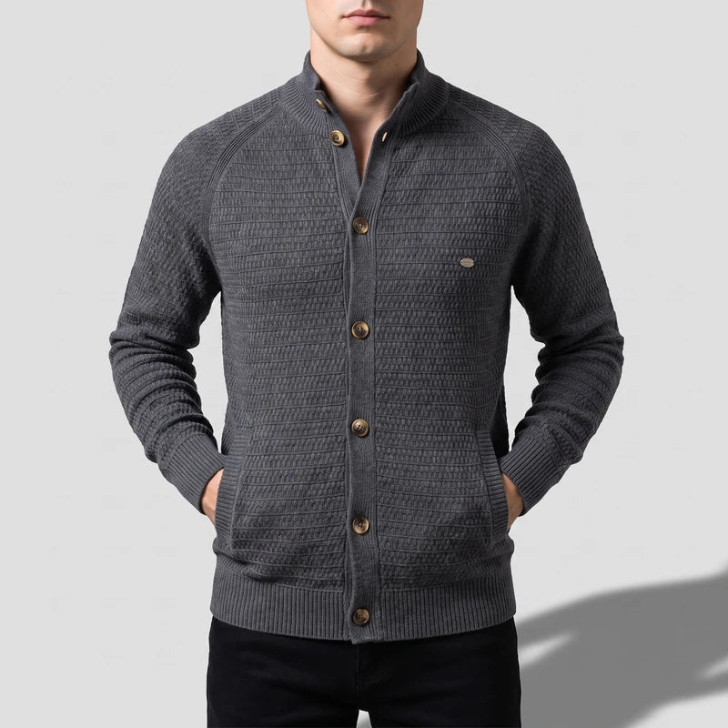 Man wearing a dark gray knit cardigan with a stand-up collar, five brown buttons, and ribbed cuffs and hem.