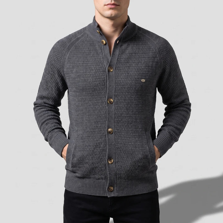 Man wearing a dark gray knit cardigan with a stand-up collar, five brown buttons, and ribbed cuffs and hem.