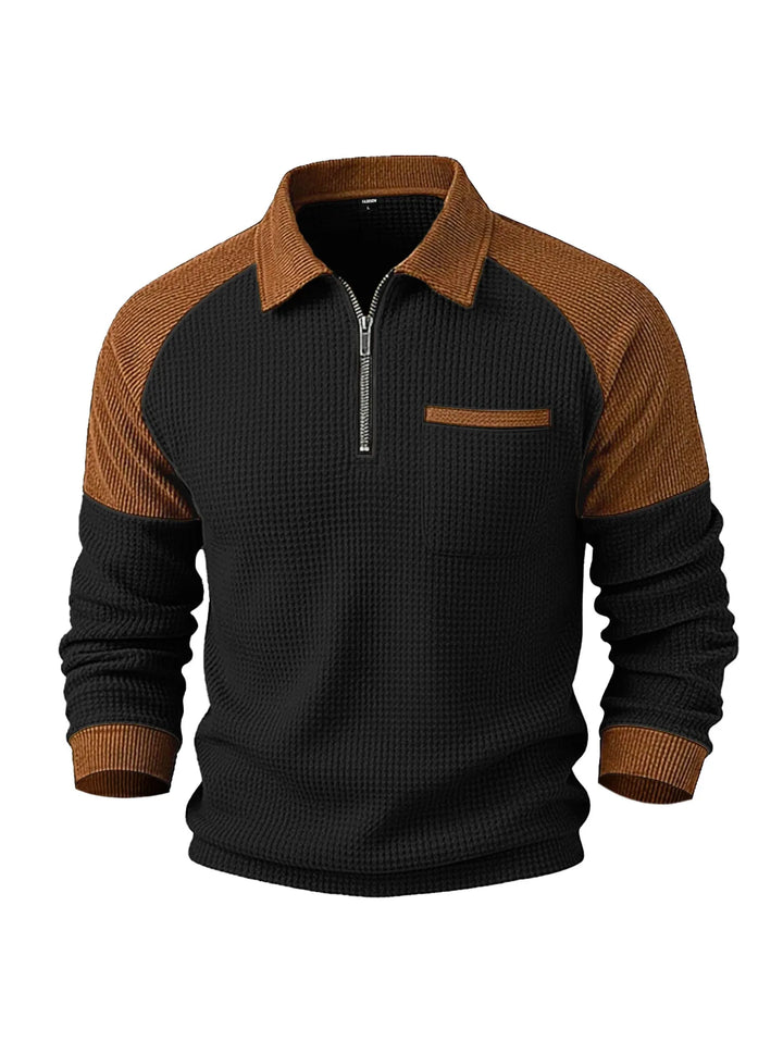 Front view of a men's black and brown waffle-knit top with a half-zip front and a pointed collar.