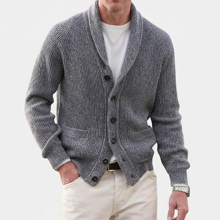 Man wearing a grey ribbed knit cardigan with a large shawl collar, dark buttons, and two front pockets.
