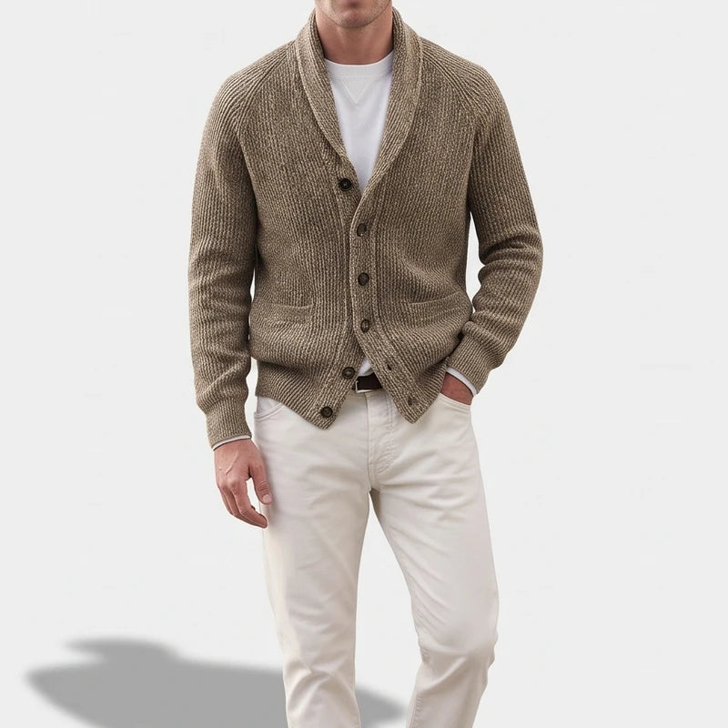 Man wearing a textured, ribbed knit, fawn-colored cardigan with a shawl collar, five buttons, and two pockets.