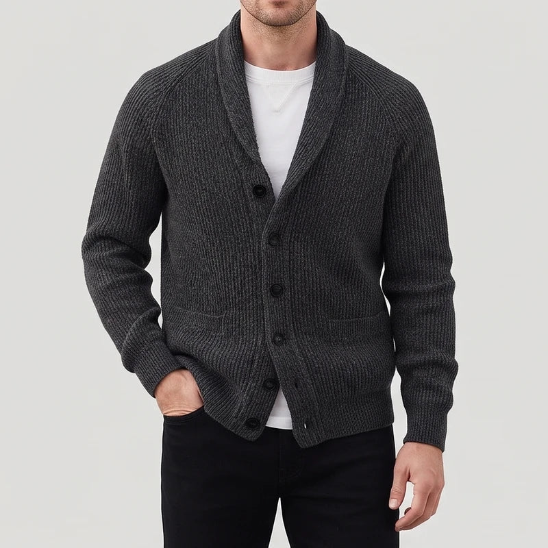 Man wearing a dark gray ribbed knit cardigan with a shawl collar, black buttons, and two front pockets.