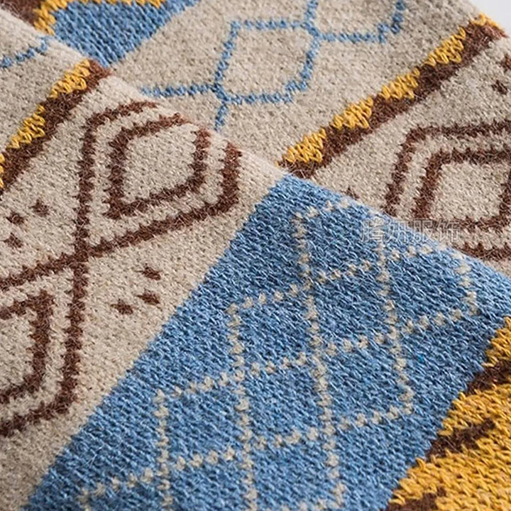 Close-up of a beige, blue, brown, and yellow knit fabric folded with geometric diamond and stripe patterns.