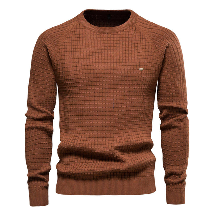 Terracotta brown knit sweater with a textured grid pattern, crew neck, and raglan sleeves, displayed flat.
