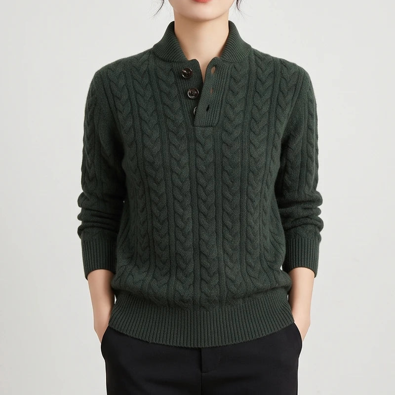 Woman wearing a dark green cable knit sweater with a stand-up collar and three brown buttons on a half-placket.