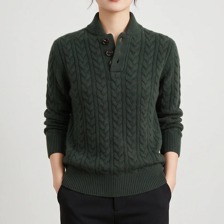 Woman wearing a dark green cable knit sweater with a stand-up collar and three brown buttons on a half-placket.