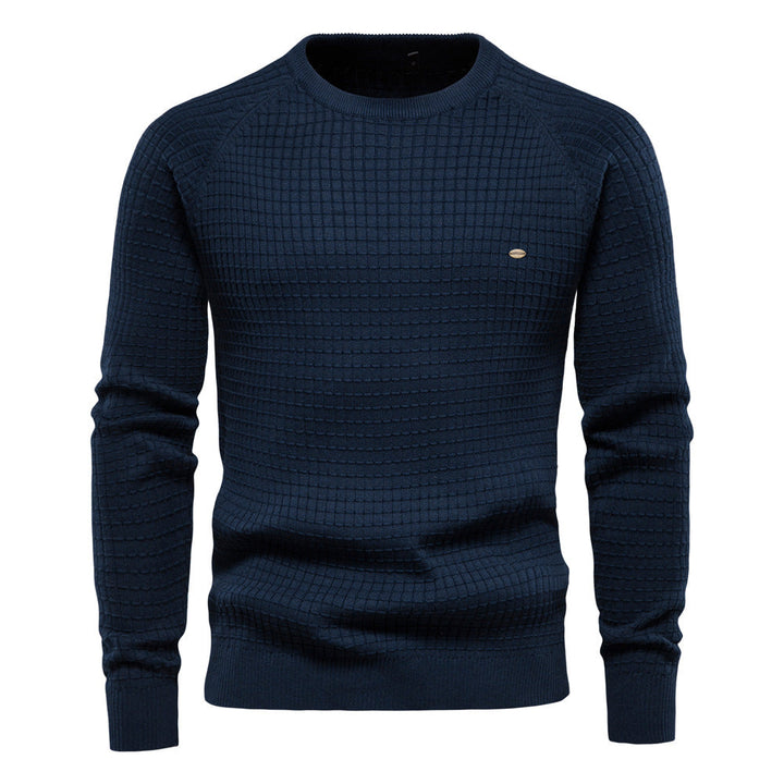 Navy blue waffle knit sweater with raglan sleeves and a small oval emblem on the chest.
