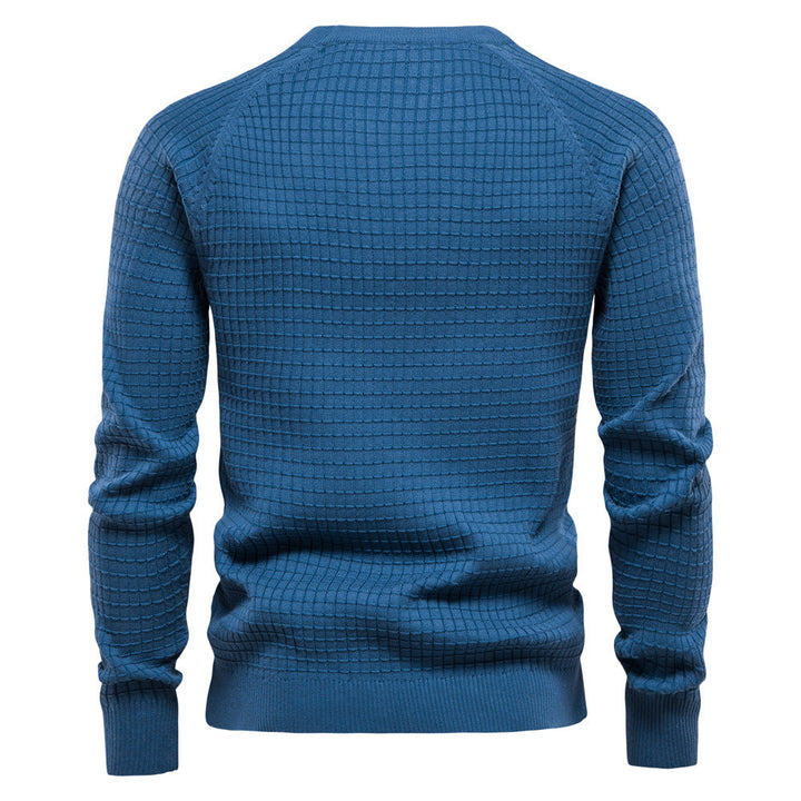 Back view of a blue knit sweater featuring a waffle texture, raglan sleeves, and ribbed cuffs and hem.