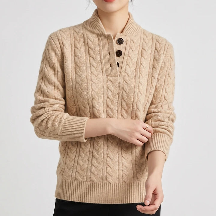 Woman wearing a beige cable knit sweater with a collared henley neckline and three dark brown buttons, posed against a white background.