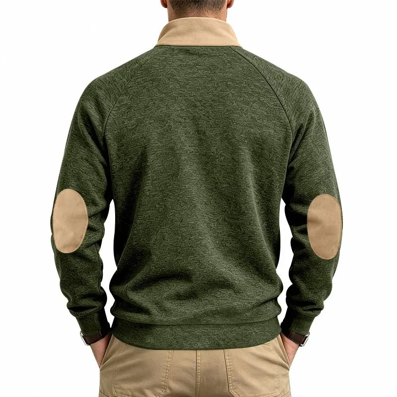 Man wearing a dark green marled half-zip top with a tan collar and tan elbow patches, seen from the back.