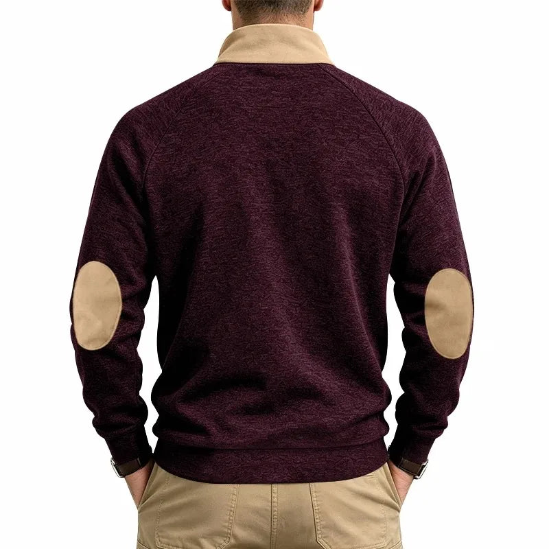 Man wearing a burgundy knit sweatshirt with textured material, tan elbow patches, and a tan stand-up collar, seen from the back.