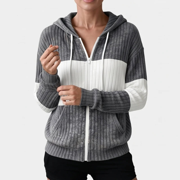 Woman wearing a gray and white ribbed knit zip-up hoodie with a drawstring hood and front pockets.