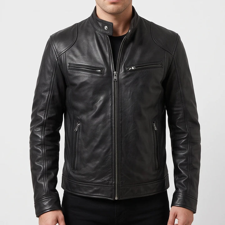 Man wearing a fitted black leather biker jacket with zippered pockets and a snap collar against a plain studio background.