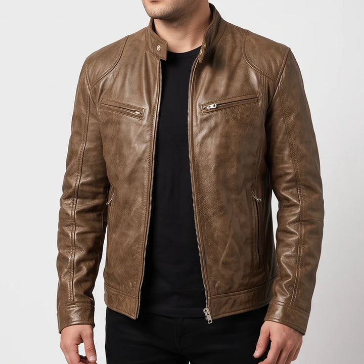 Man wearing a brown leather biker jacket featuring zippered pockets and a snap collar over a black shirt.