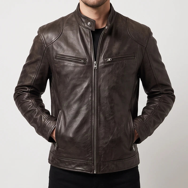 Man wearing a dark brown leather biker jacket with zippered chest pockets and a snap collar against a plain studio background.