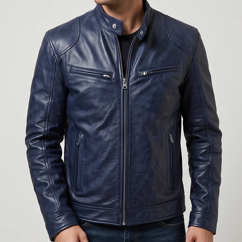 Man wearing a navy blue leather biker jacket with multiple zippered pockets and a snap collar against a plain background.