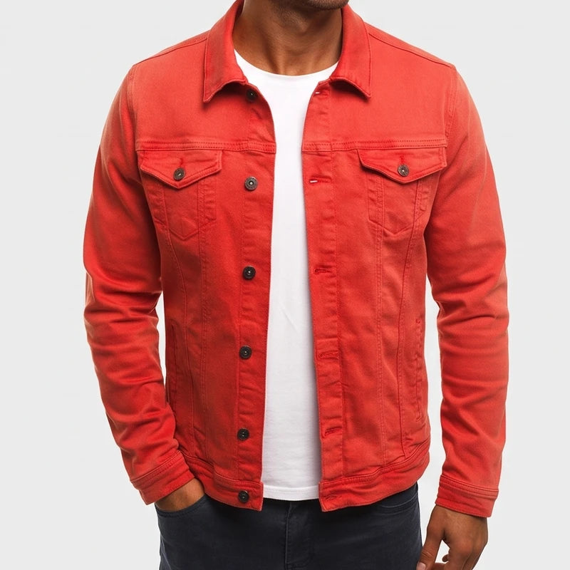 Man wearing a vibrant red denim jacket with black buttons, chest pockets, and a pointed collar, hand in pocket.