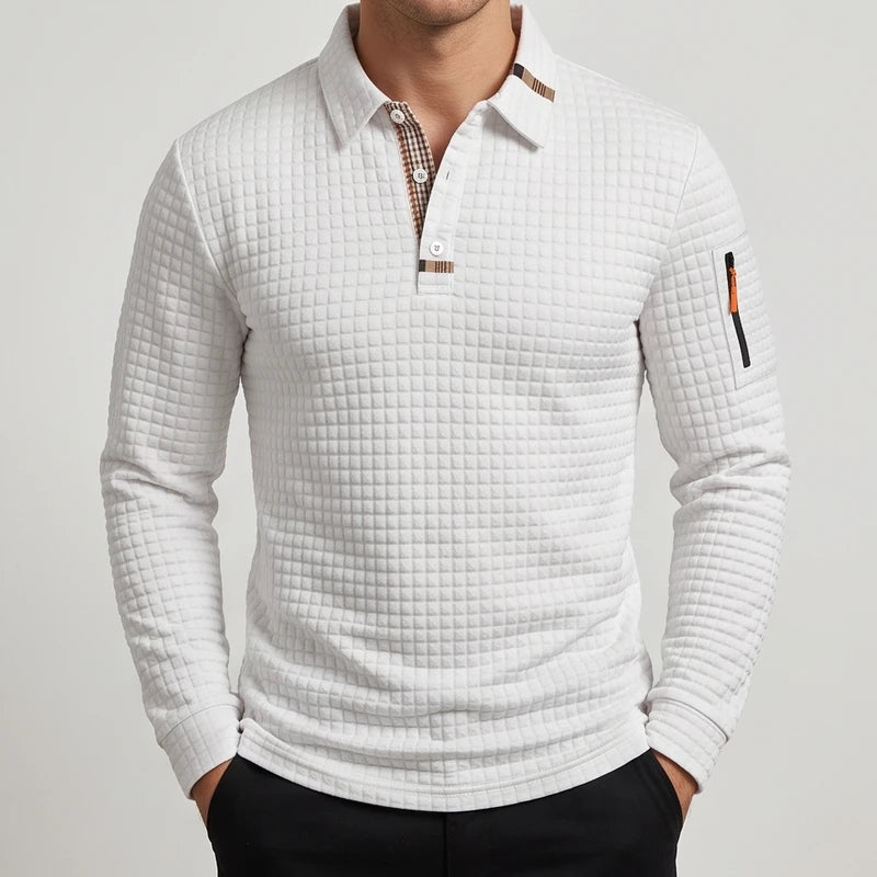 Man wearing a white quilted long sleeve polo shirt with a plaid collar lining and a small zippered sleeve pocket.