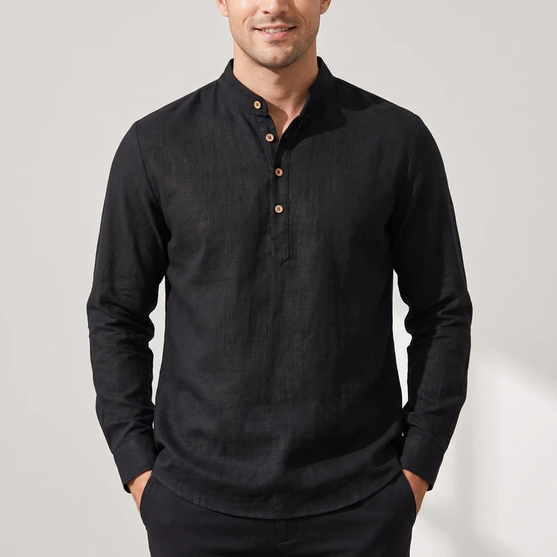 Man wearing a black linen long sleeve shirt with a band collar, three light brown wooden buttons, and a buttonless placket.