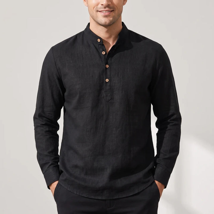 Man wearing a black linen long sleeve shirt with a band collar, three light brown wooden buttons, and a buttonless placket.