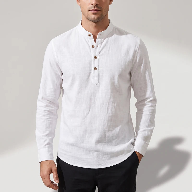 Man wearing a white, textured long-sleeve shirt with a band collar and three visible brown buttons.