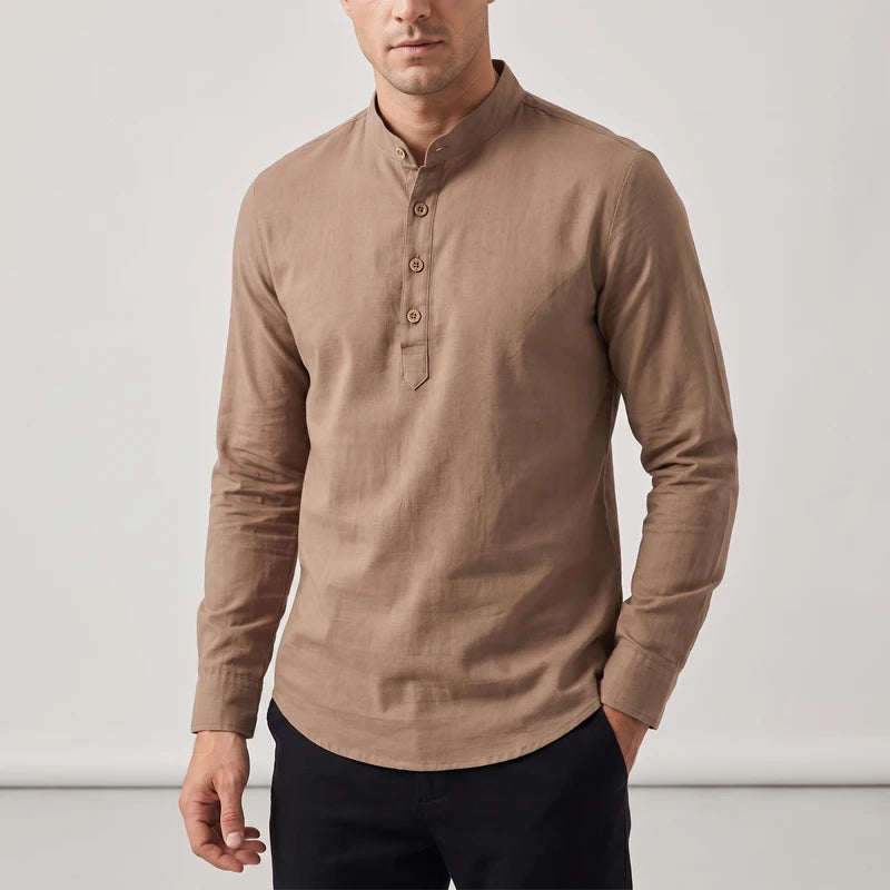 Man wearing a long sleeve collared shirt in tan brown with a four-button placket and rounded hem, hand in pocket.