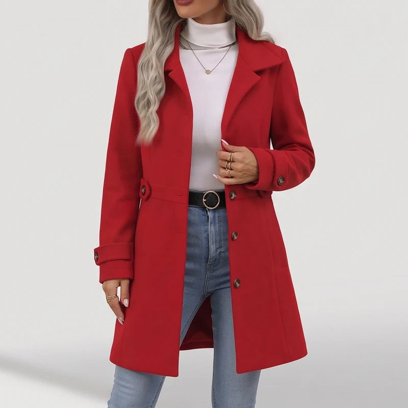 Woman wearing an open bright red wool coat with a white turtleneck, light blue jeans, and a black belt.