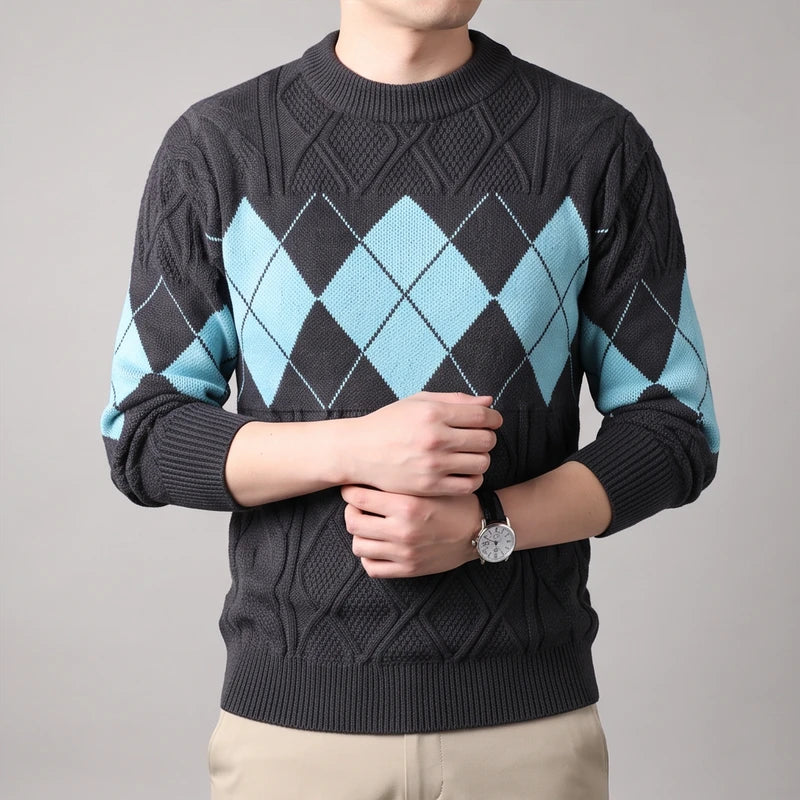 Man wearing a dark gray cable knit sweater with a light blue argyle pattern across the chest and sleeves.