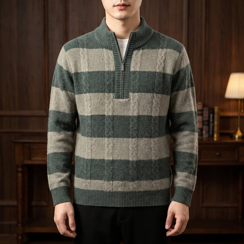 Man wearing a striped half-zip pullover sweater with alternating green cable knit and light grey ribbed patterns.