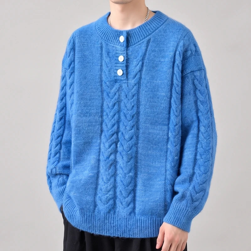 Man wearing a bright blue, fluffy cable-knit sweater with white buttons and a relaxed fit, standing against a neutral background.