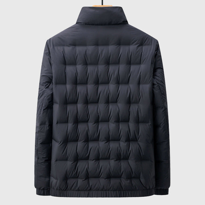 Back view of a dark navy puffer jacket with a mock neck and square quilted baffles, hanging on a hanger.