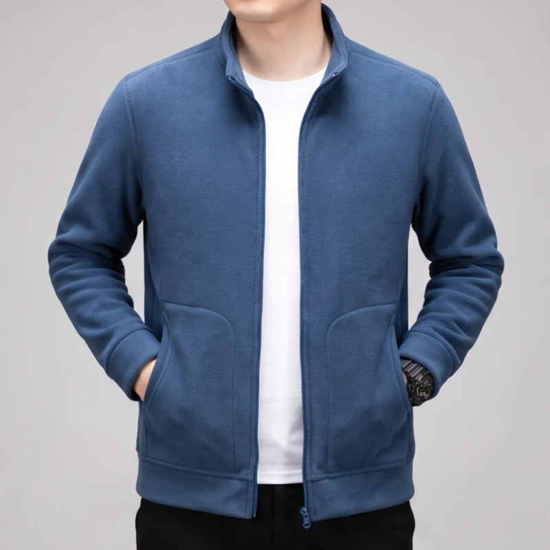 Blue fleece jacket on an off-gray studio background