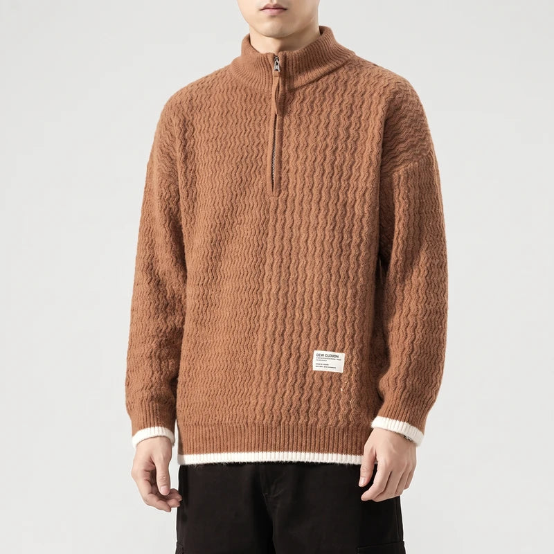 Man wearing a brown textured knit half-zip sweater with a high collar and white striped cuffs and hem.