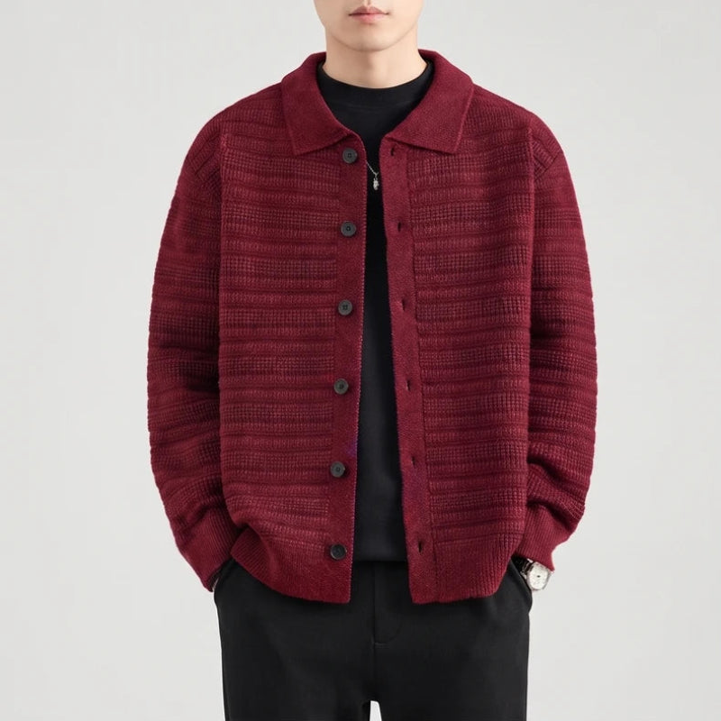 Man wearing a burgundy knit button-front cardigan with a patterned texture and a collar over a black shirt.