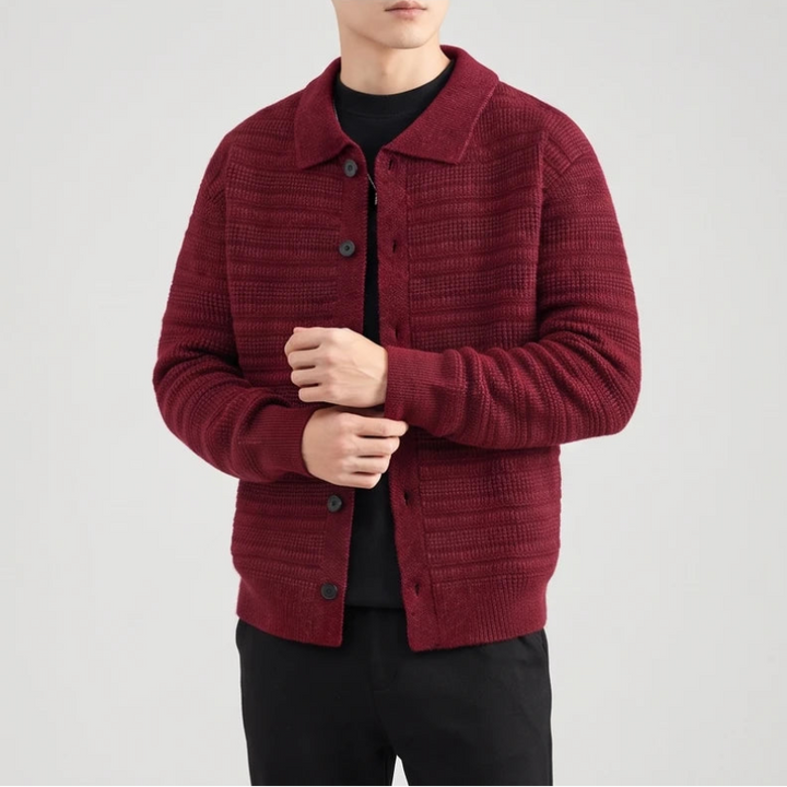 Man wearing a textured, dark red knit cardigan with a collar and black buttons, over a black shirt and pants.