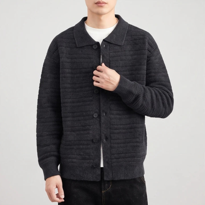 Man wearing a dark charcoal gray button-front knit cardigan with a textured horizontal stripe pattern and a collar.