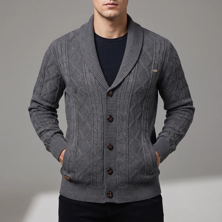 Man wearing a dark gray knitted cardigan with diamond cable pattern, shawl collar, and dark brown buttons.