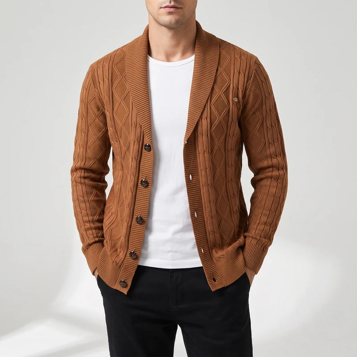 Man wearing an open brown cable knit cardigan with a wide shawl collar over a white t-shirt.