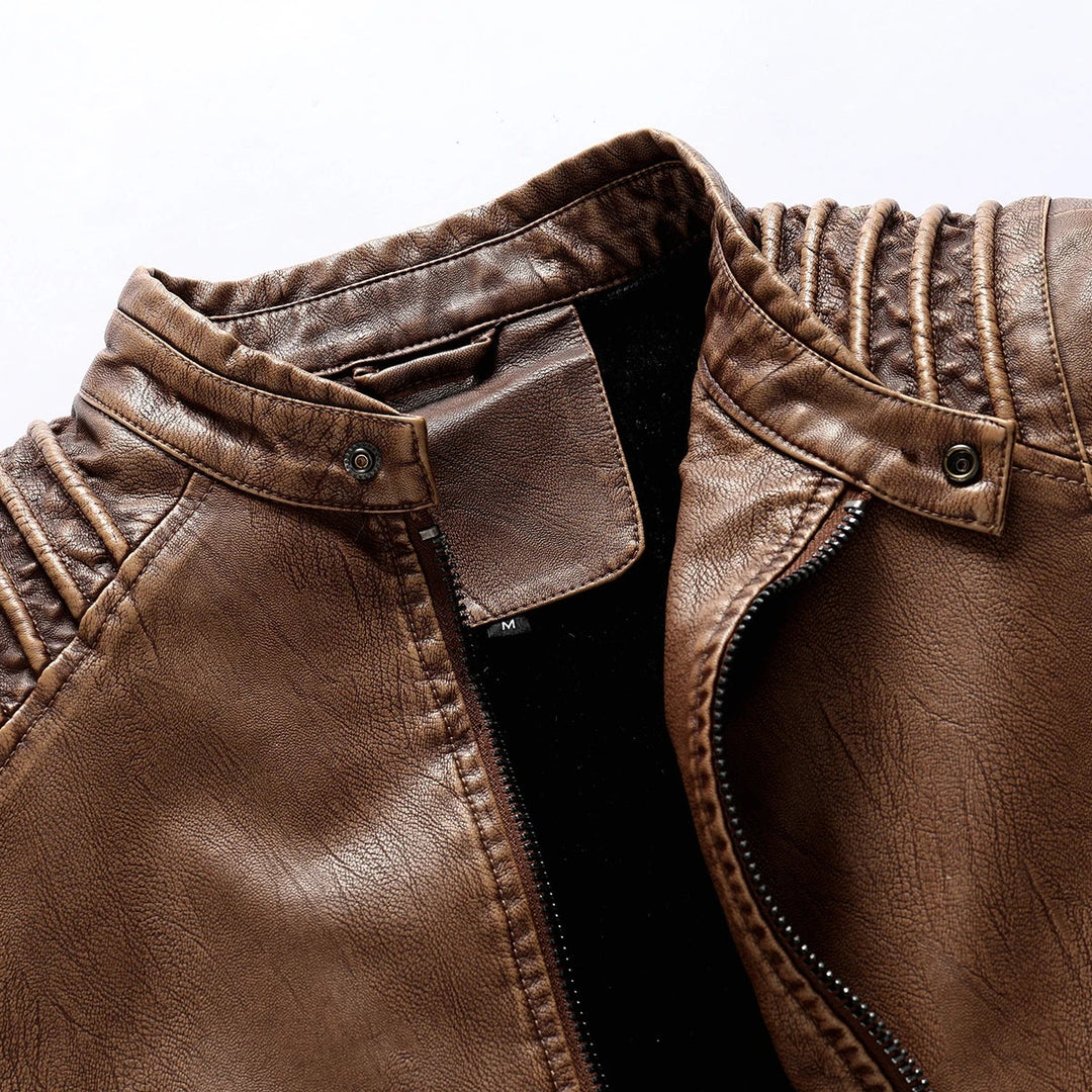 Close-up of a weathered brown leather jacket with a zippered front, ribbed shoulder details, and a snap-button collar.