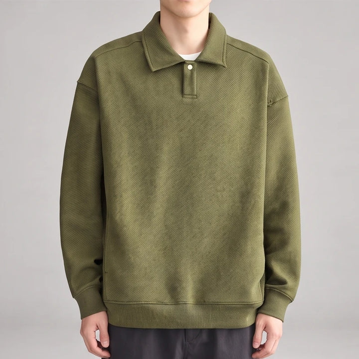 Man wearing a muted olive green long-sleeve polo sweatshirt with a textured diagonal stripe pattern and single button placket.