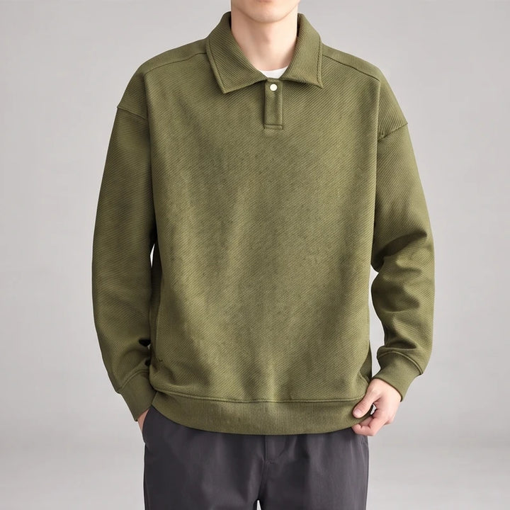 Man wearing a relaxed-fit olive green long-sleeve polo sweatshirt with a diagonal ribbed texture and single button placket.