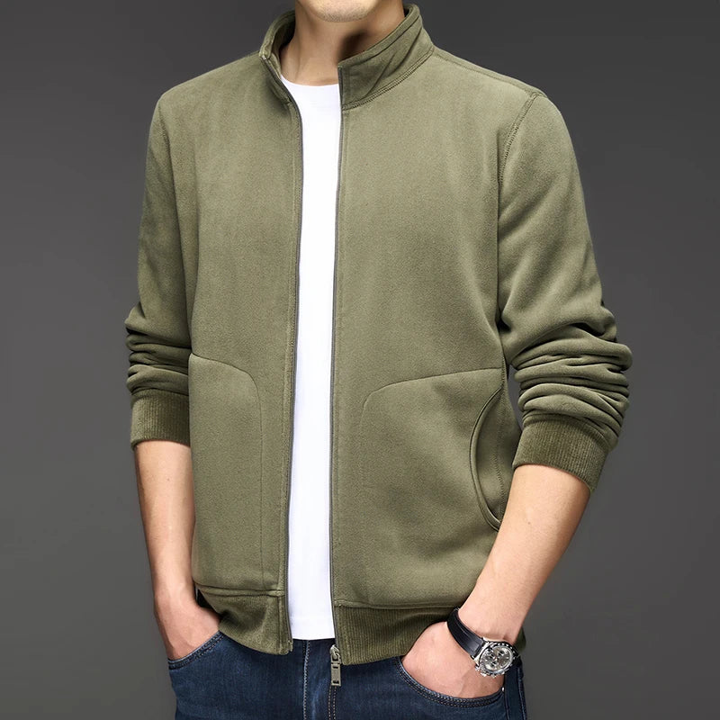 Man wearing an olive green zip-up jacket with a ribbed stand-up collar, cuffs, and hem, over a white t-shirt.